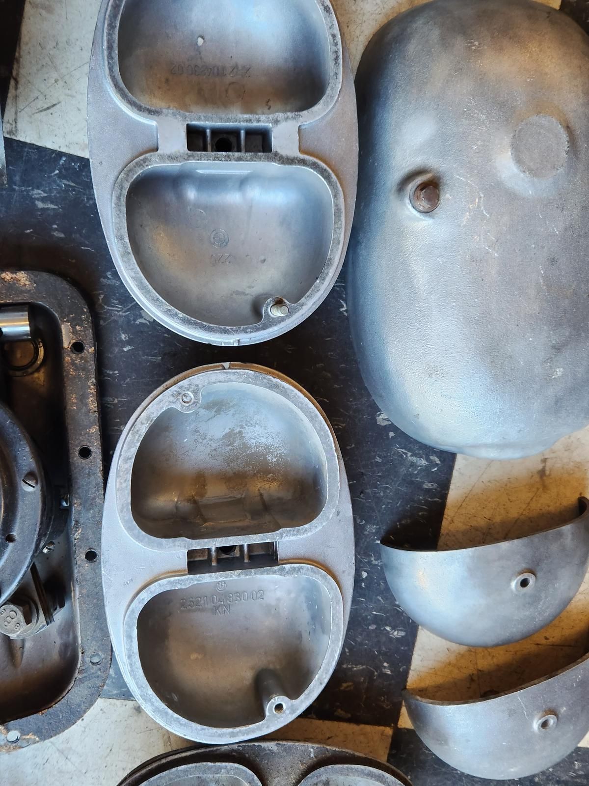 A bunch of metal pieces are sitting on a checkered floor.