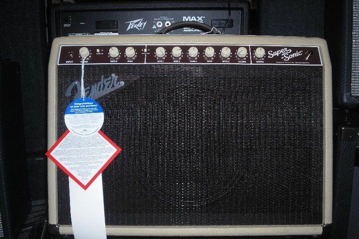 Black Fender guitar amplifier with control knobs and price tag hanging on the left