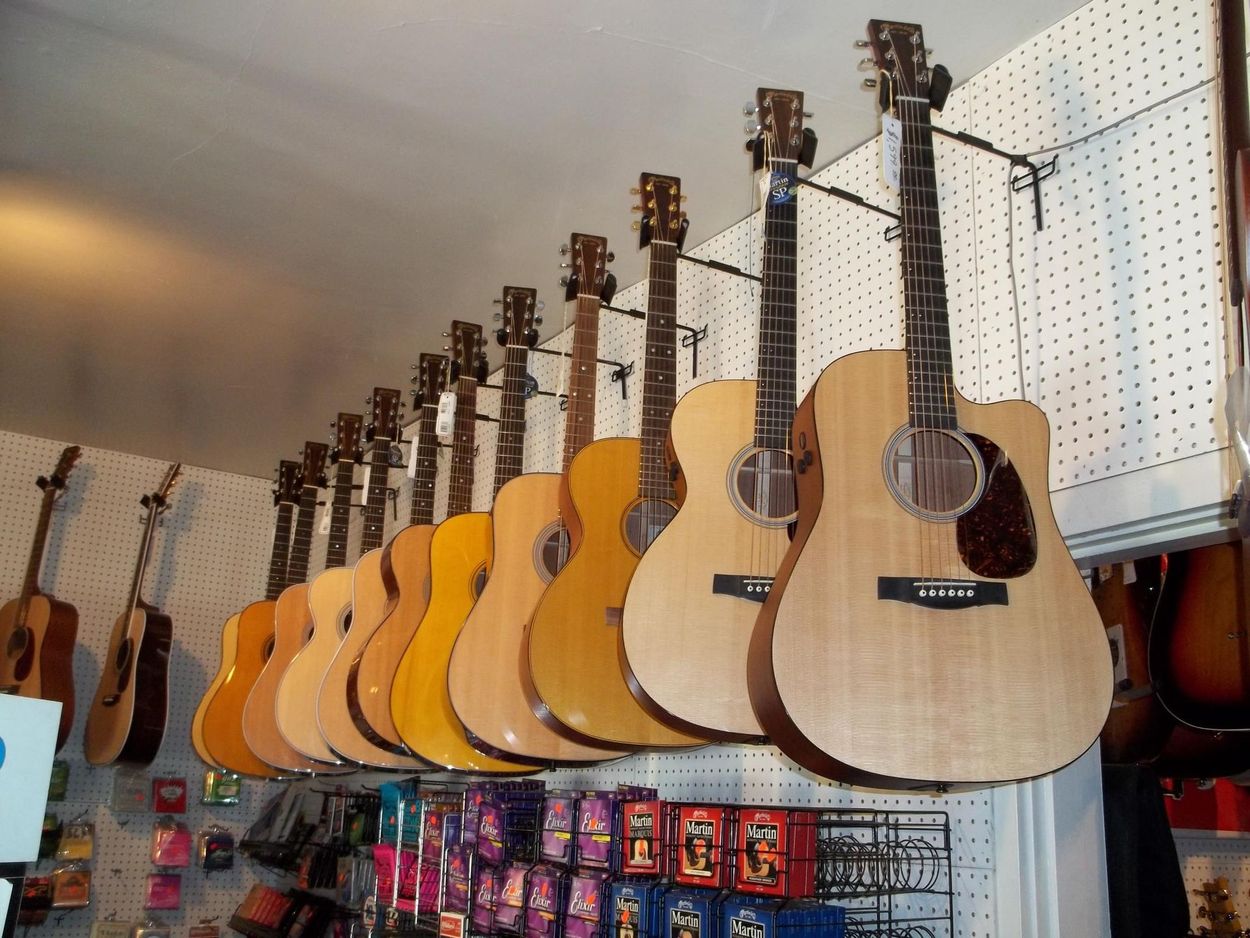 Row of acoustic guitars hanging in a music store display