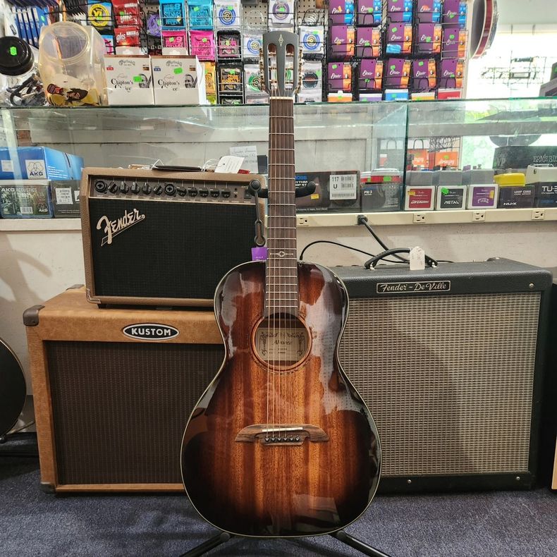 Sunburst acoustic guitar between two Fender amplifiers in a music shop