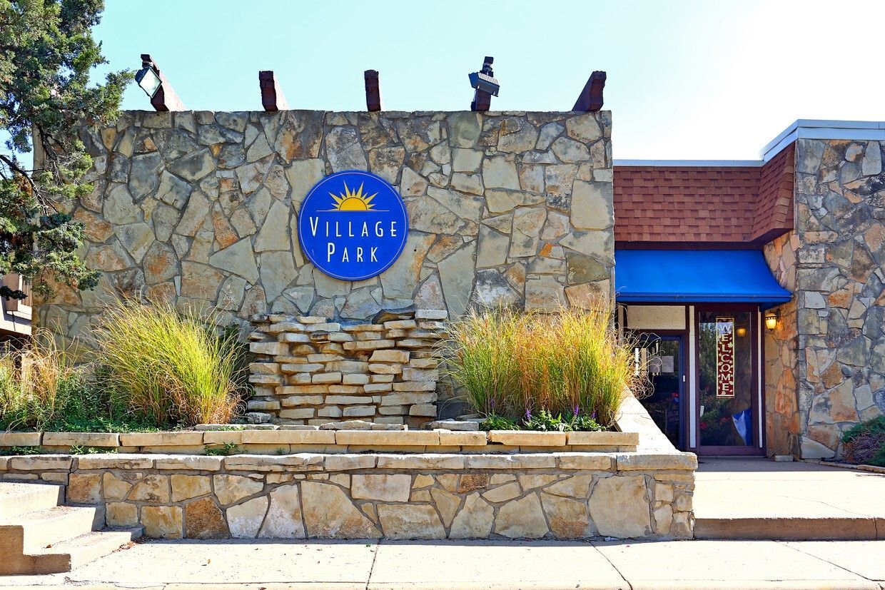Stone-faced building with a blue awning, a sign reading "Re-Enock Fund," and decorative grass.