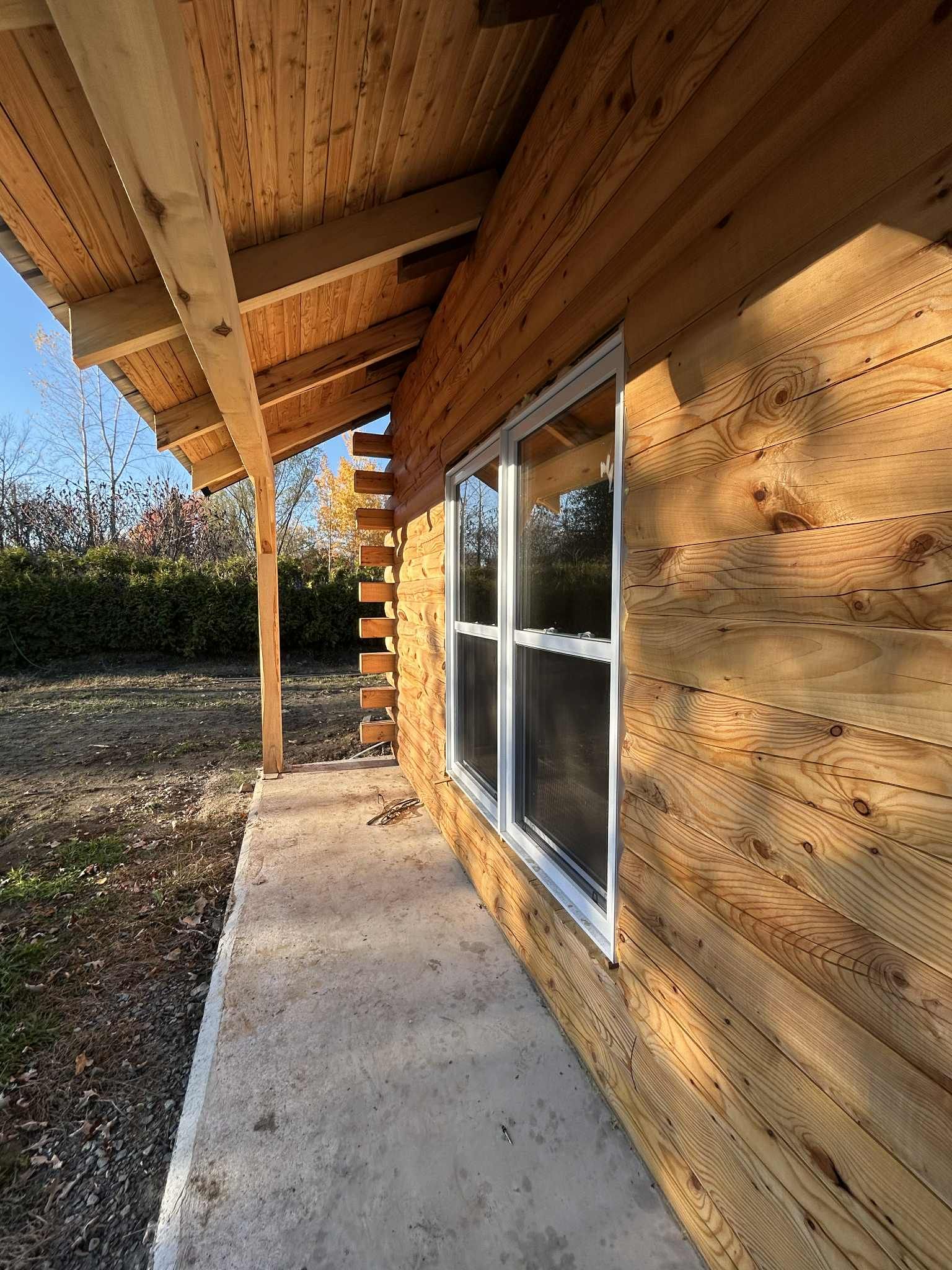 Extérieur d'un bâtiment en bois avec une fenêtre et un porche.