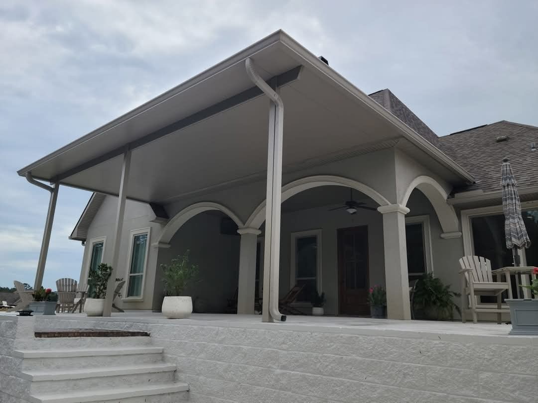 Modern house patio with arched columns, steps, and a sloped roof under a cloudy sky