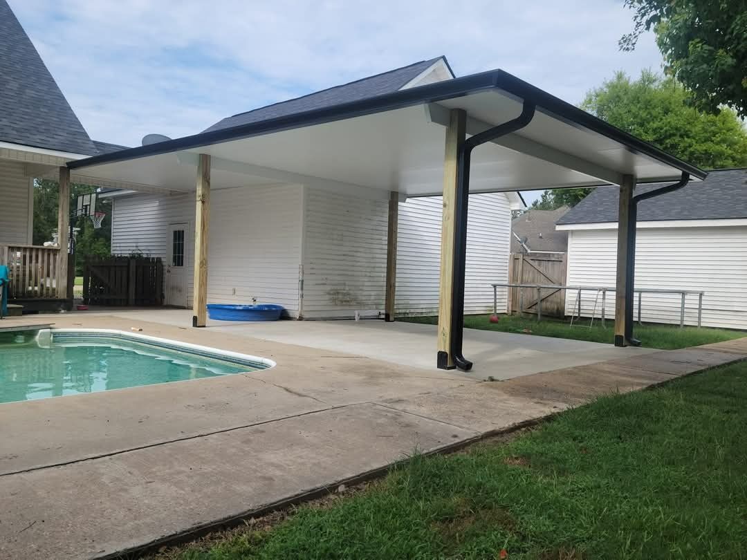 Backyard patio with a pool, covered seating area, white siding, and green lawn