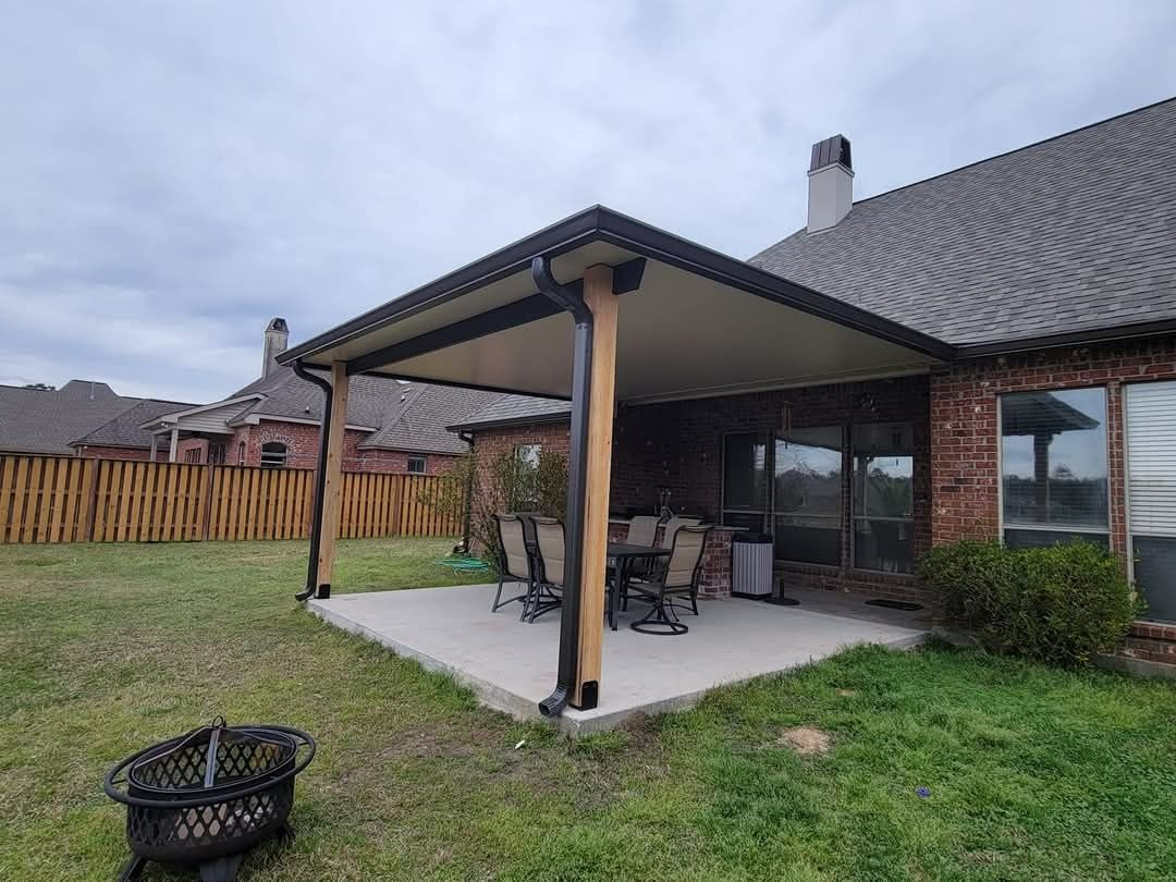 Back patio with covered porch, outdoor seating, and a grassy yard beside a house