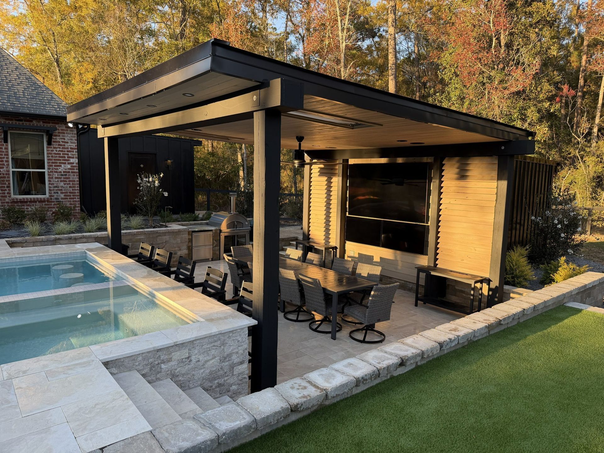 Modern backyard patio with black pergola, seating area, and pool beside a house