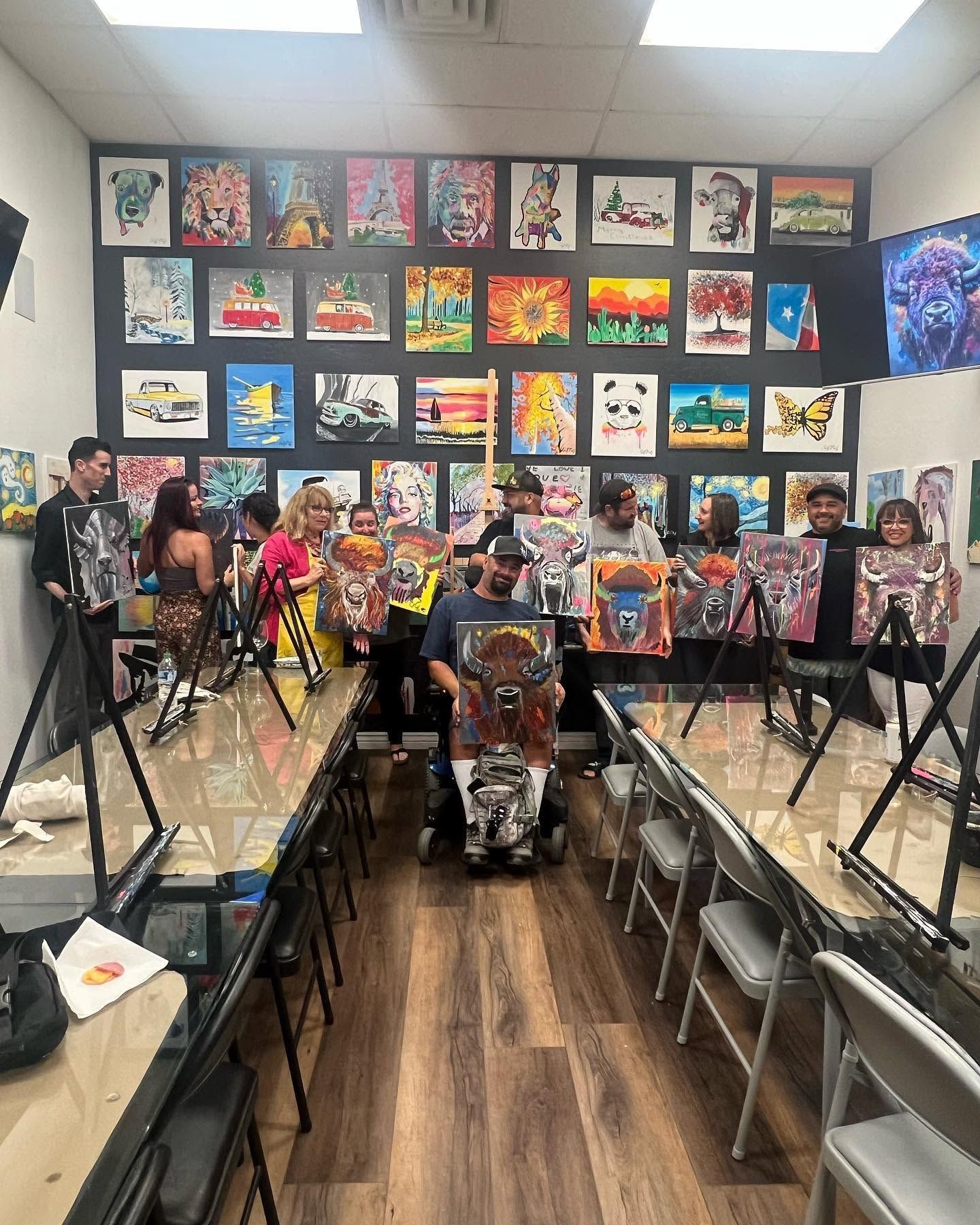 Colorful classroom art display with easels and chairs arranged in rows for a student art exhibit