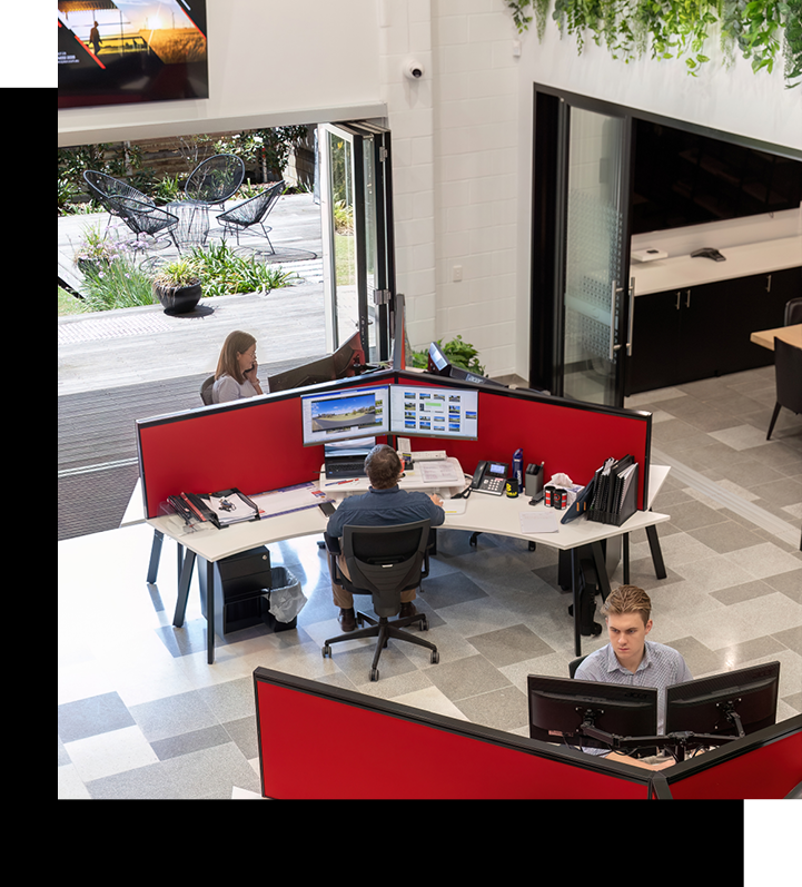 A man is sitting at a desk with two computer monitors.