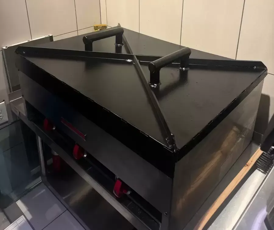 A black box with handles is sitting on a shelf