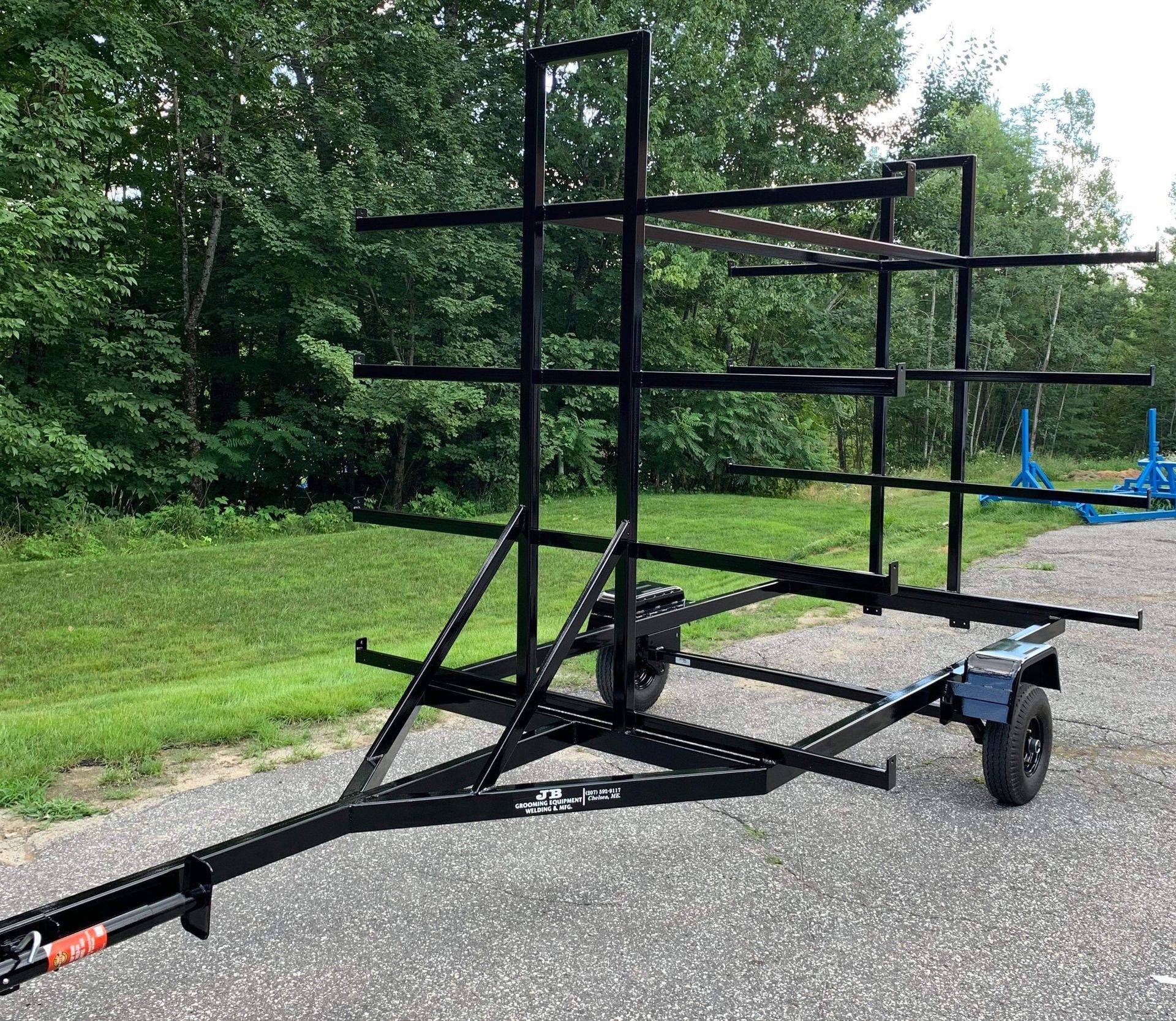 A black trailer is parked on the side of the road.