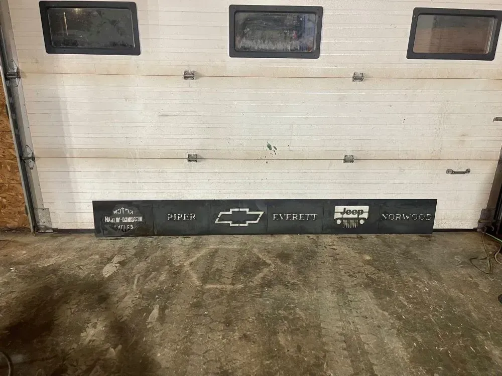 A chevrolet sign is sitting in front of a garage door.