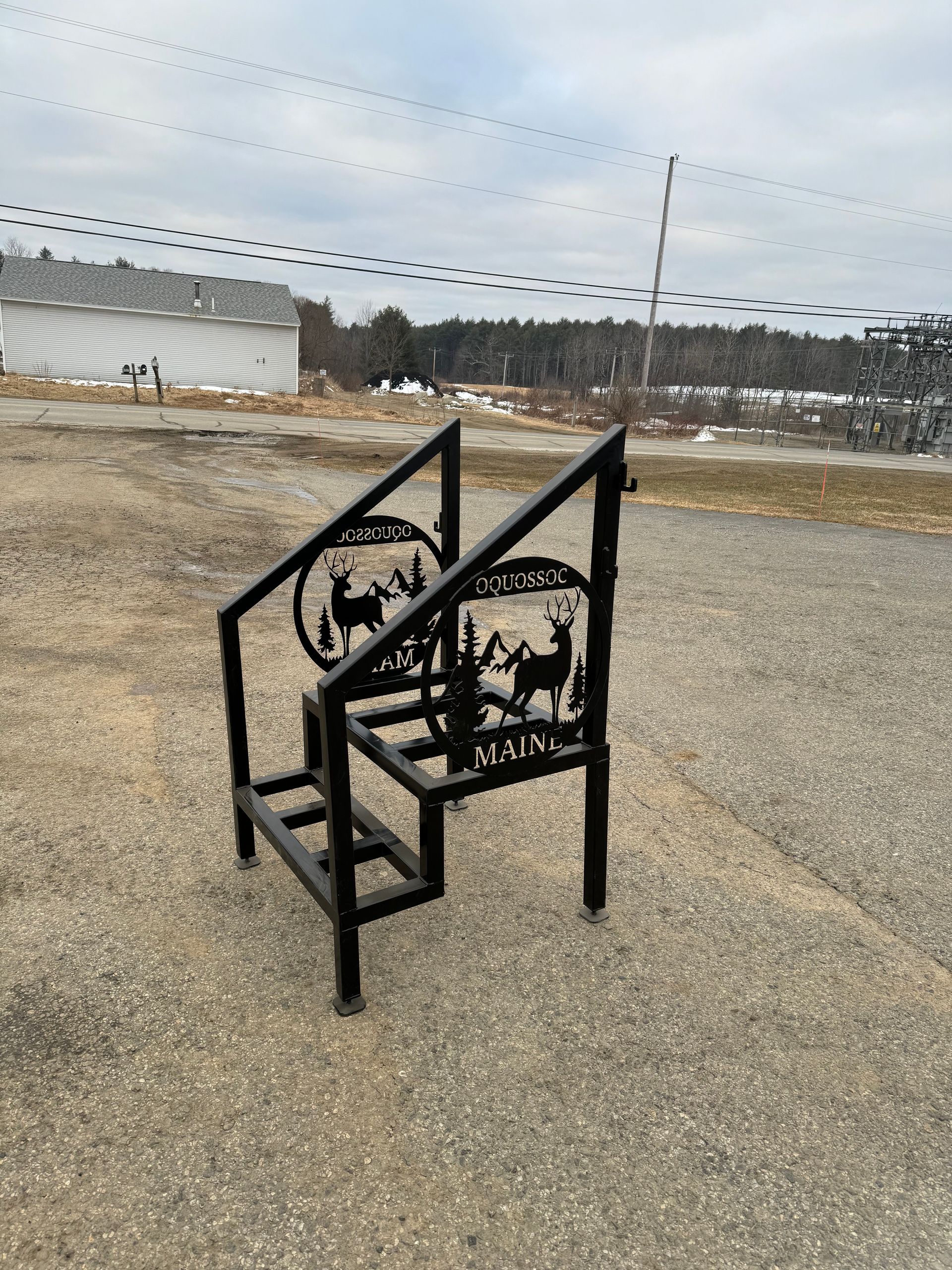 A metal staircase with a deer on it is sitting on the ground.