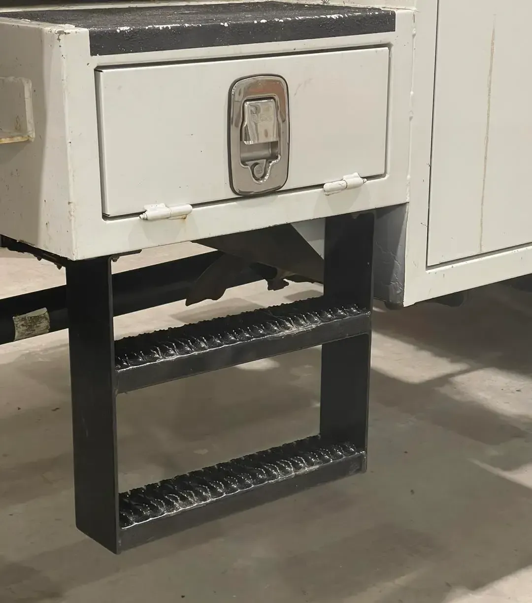 A white cabinet with a drawer and stairs attached to it.