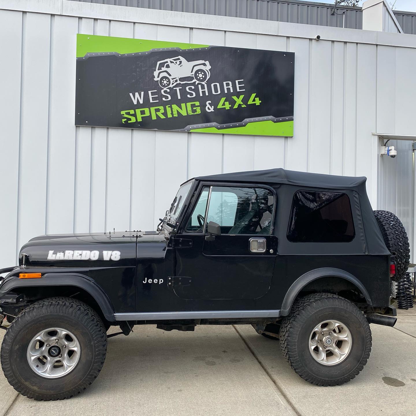 Black Jeep parked outside a shop,