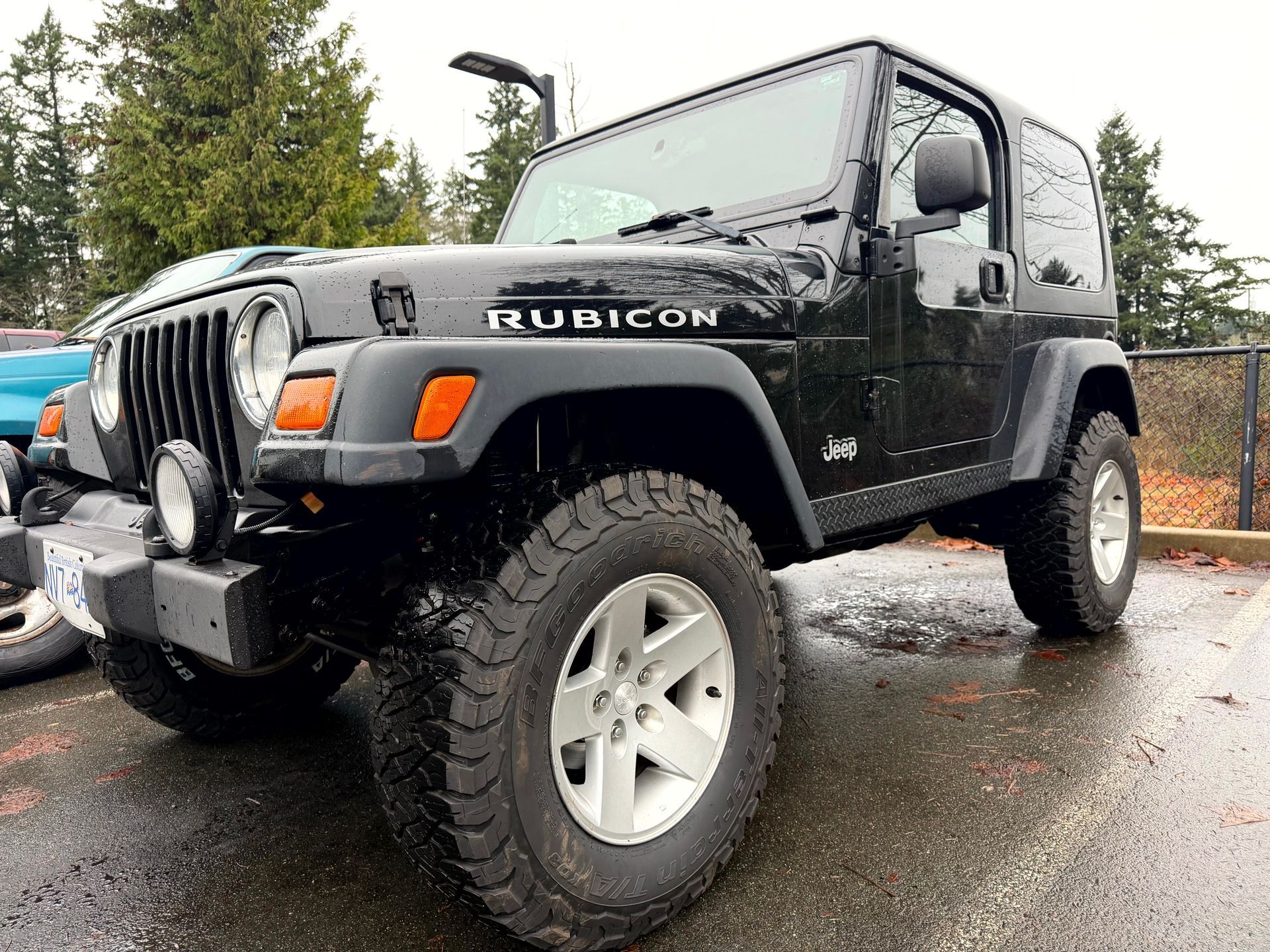 Black Jeep Wrangler Rubicon parked outdoors with large tires.