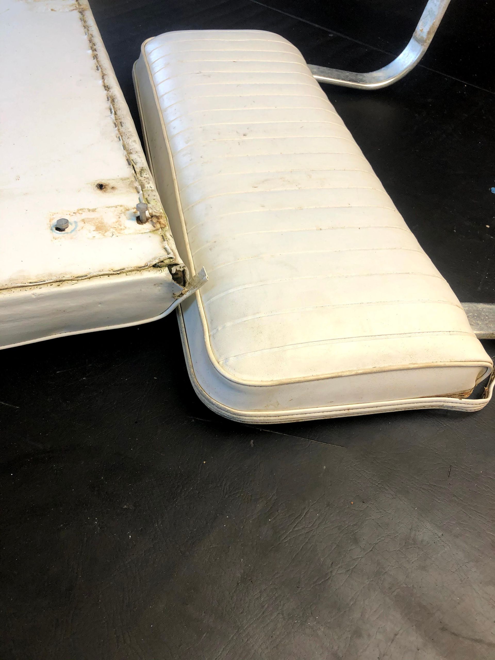 White boat seat cushions on a black surface.