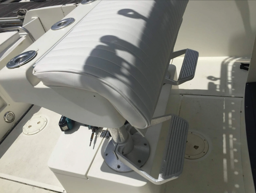 White boat seat with footrests, attached to a white surface.