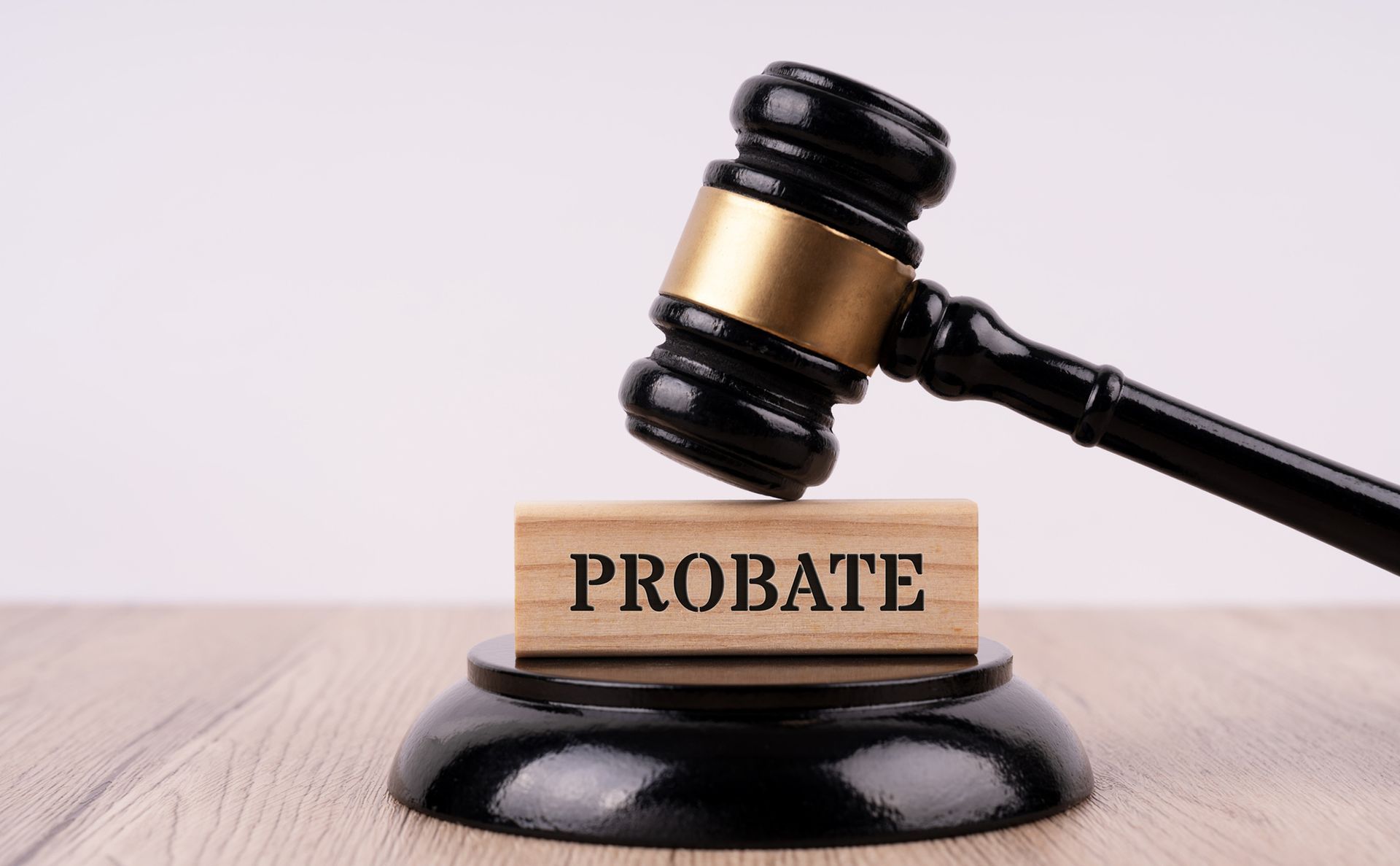 A gavel resting on a wood block engraved with the word probate.