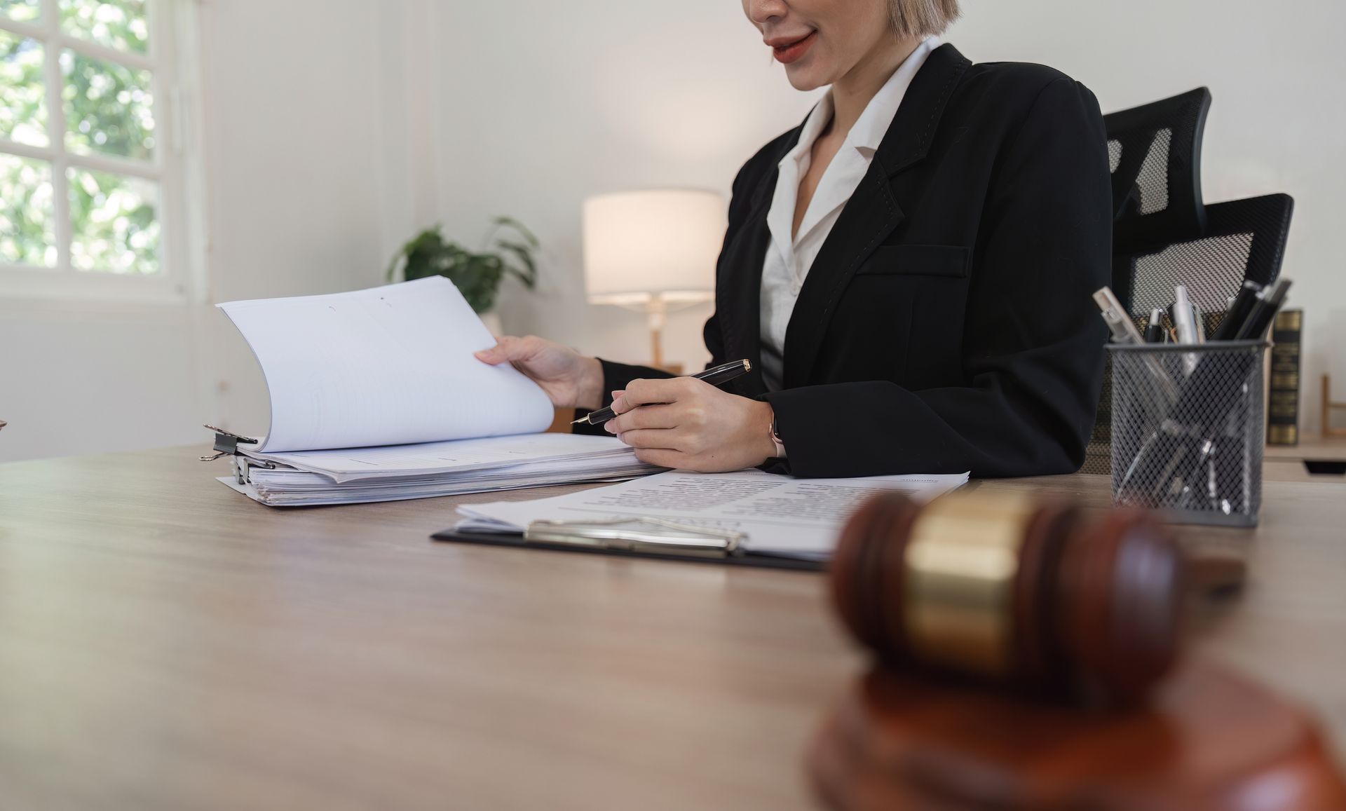 Estate planning attorney reviewing documents in a modern law office. Estate planning attorney reviewing documents in a modern law office.