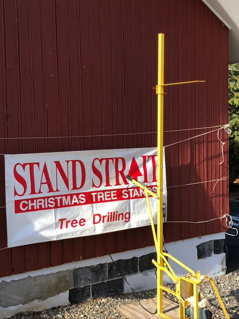 A sign that says ' stand straight christmas tree stands tree drilling ' on it