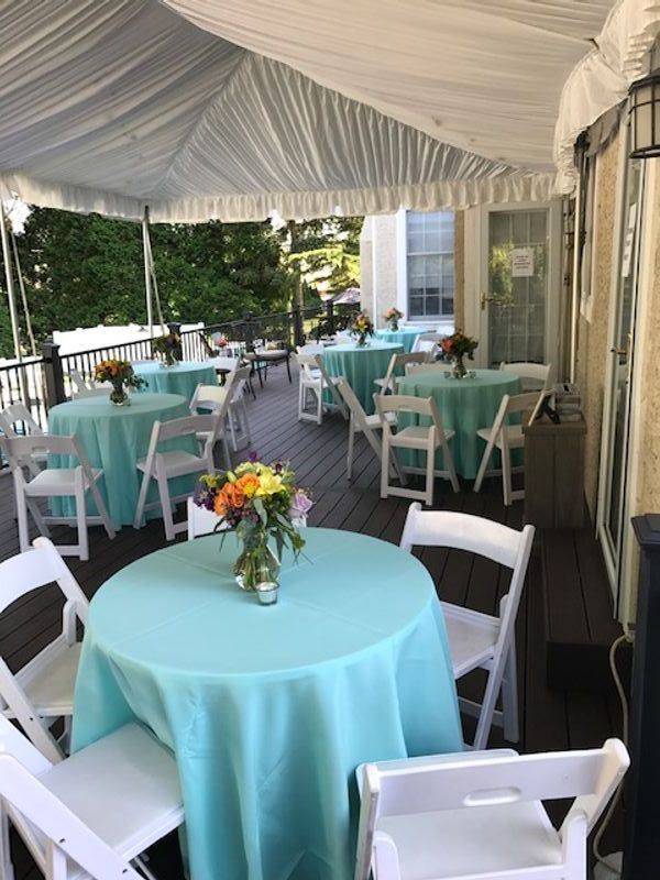 A deck with tables and chairs under a tent