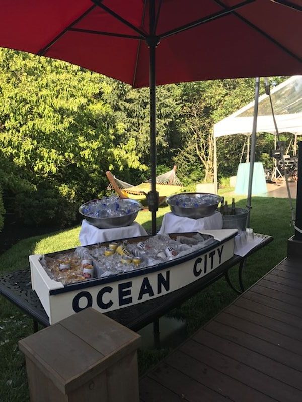 A boat with ocean city written on it sits on a table under an umbrella