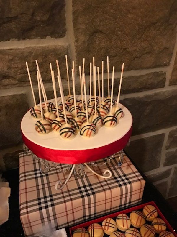A bunch of cake pops are sitting on a cake stand