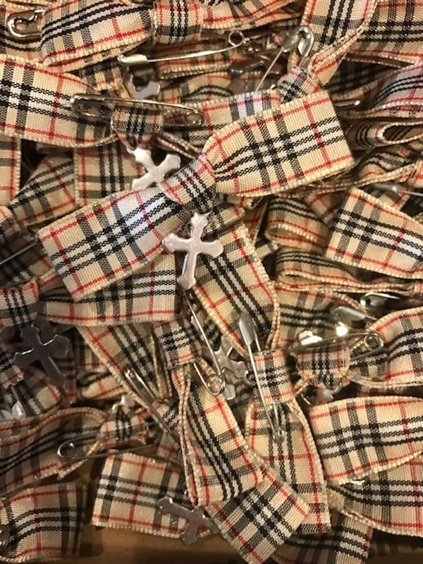 A pile of plaid hair clips with a cross on them