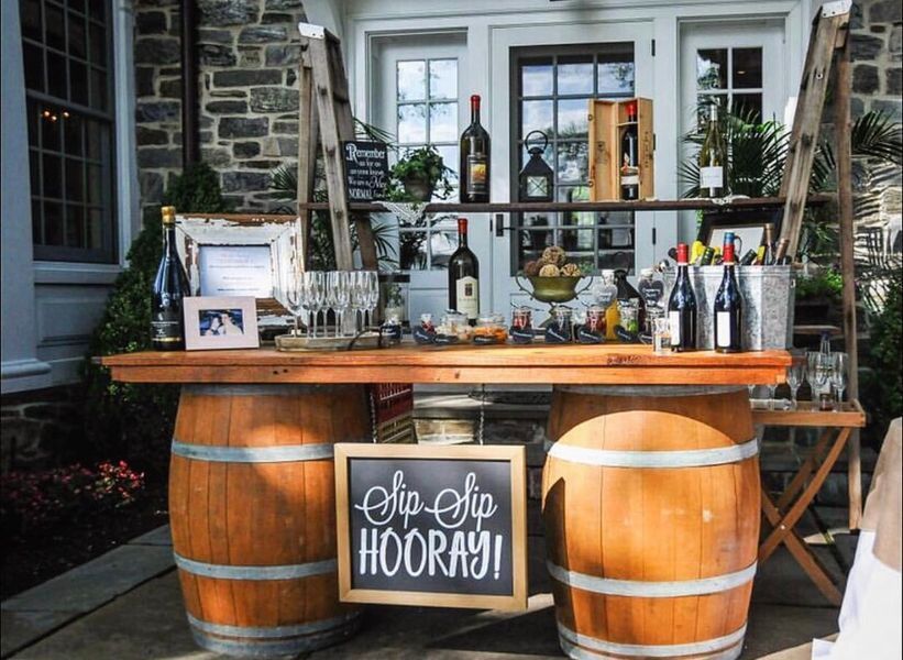 A wooden bar made out of wine barrels with a sign that says hooray