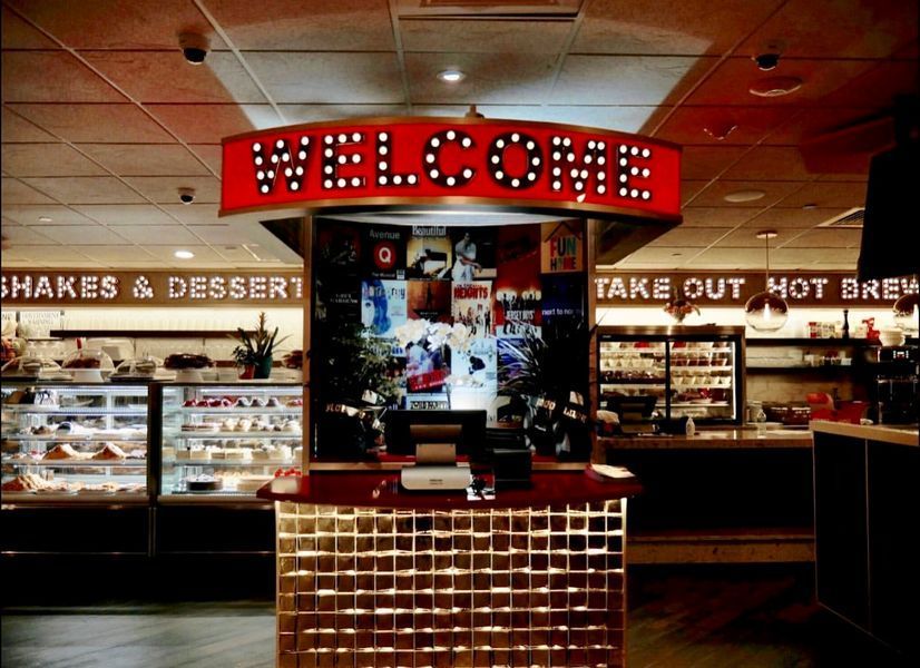 A restaurant with a welcome sign above the counter