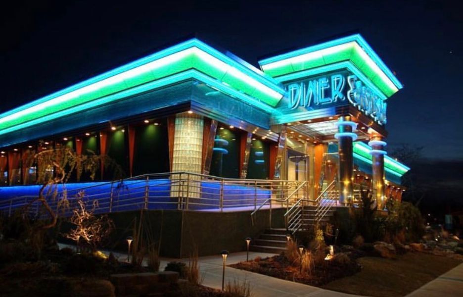 A large building with neon lights on it is lit up at night