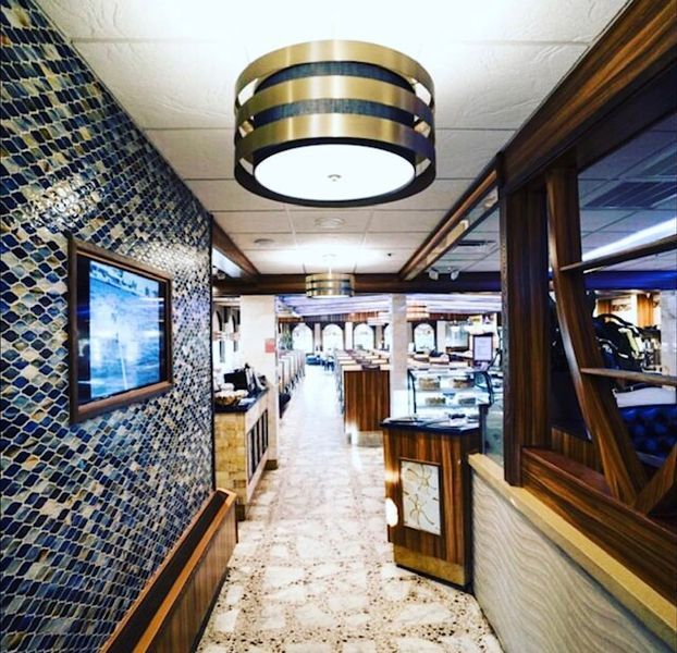 A long hallway in a restaurant with a tv on the wall