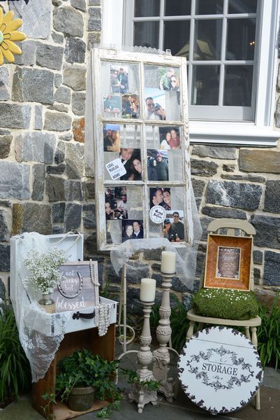 A display of pictures and candles in front of a stone wall