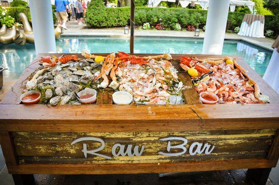 A raw bar filled with seafood is sitting next to a pool