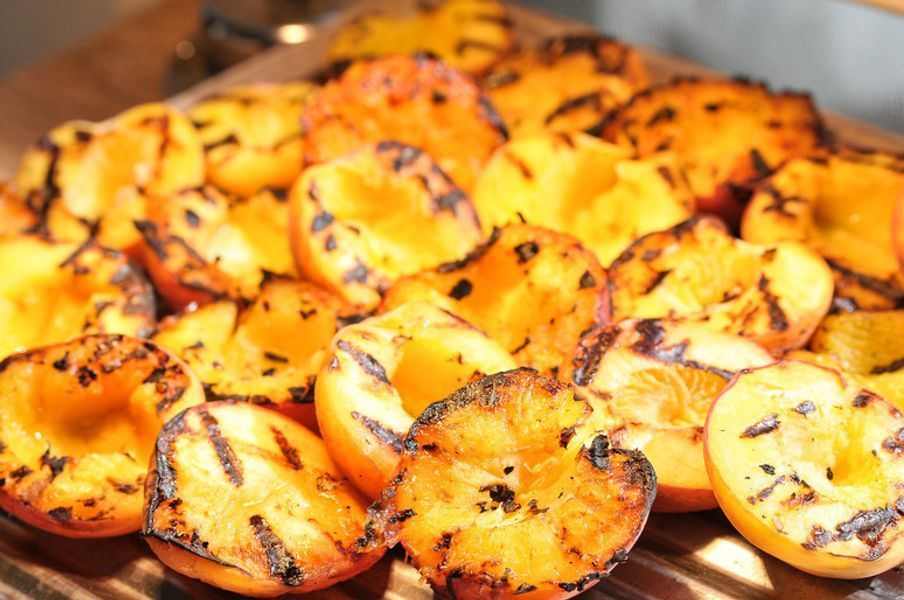 A close up of grilled peaches on a grill