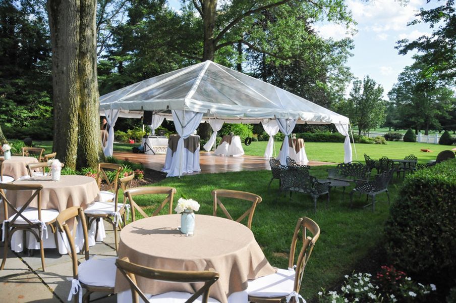 A clear tent with tables and chairs underneath it
