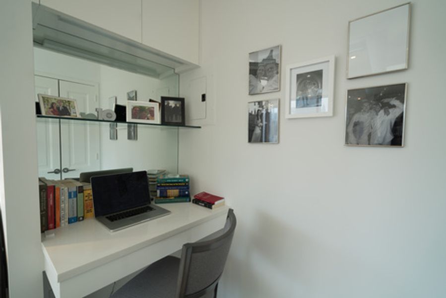A desk with a laptop on it in a room with pictures on the wall