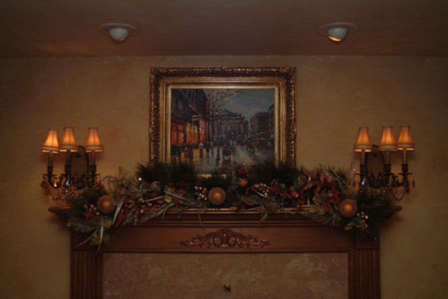 A living room with a fireplace and a painting on the wall