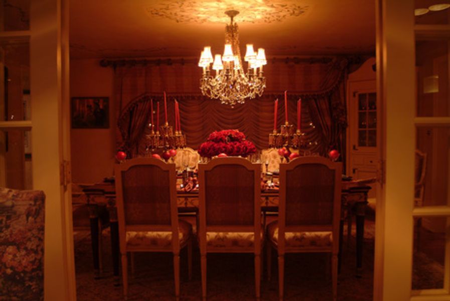 A dining room with a table and chairs and a chandelier