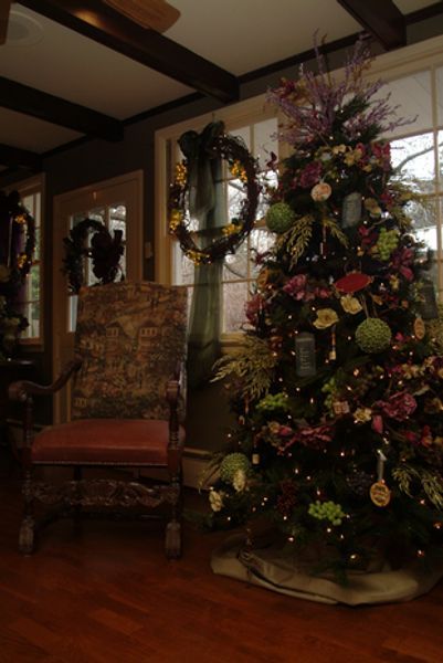 A living room with a christmas tree and a chair