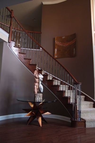 A curved staircase with a glass table in the middle