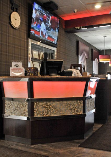 A clock hangs above a counter in a restaurant