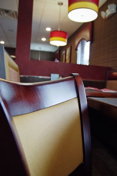 A blurry picture of a restaurant with red and yellow lamps hanging from the ceiling