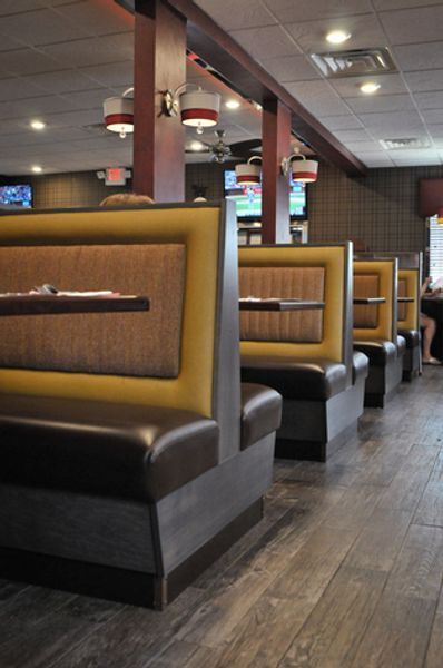 A row of yellow and brown booths in a restaurant