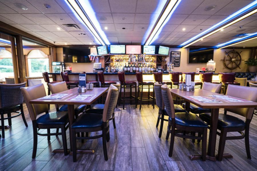 A restaurant with tables and chairs and a bar