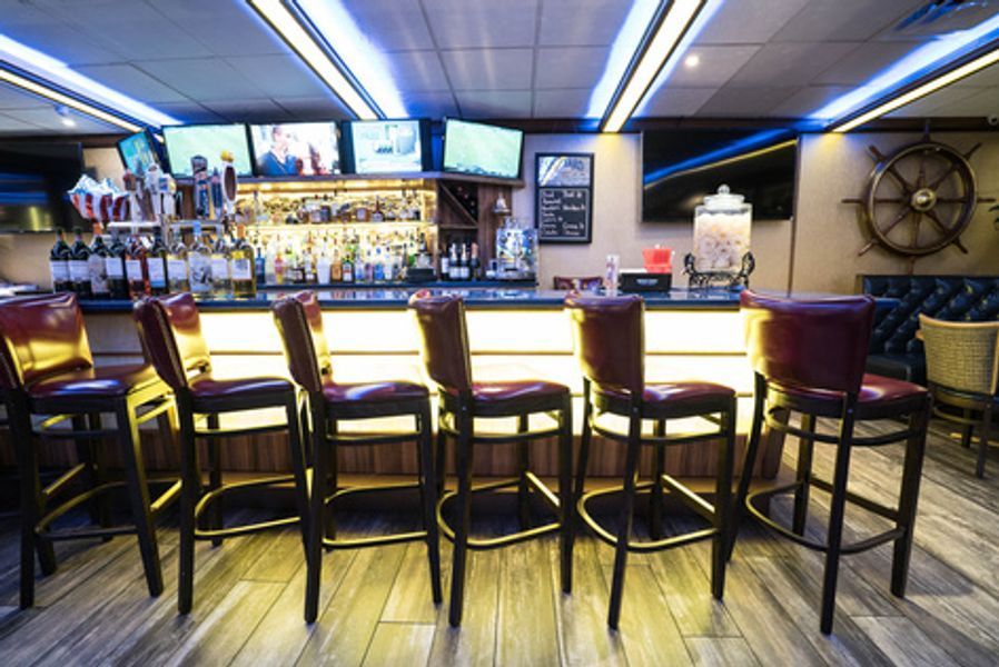 A bar with a lot of chairs and a steering wheel on the wall