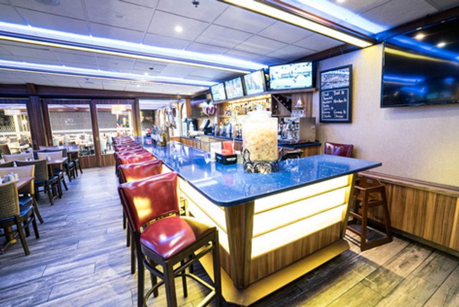 A restaurant with a long bar and a lot of chairs