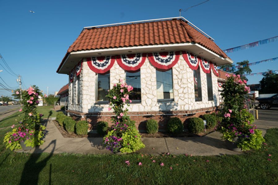 A white building with red white and blue flags on the side