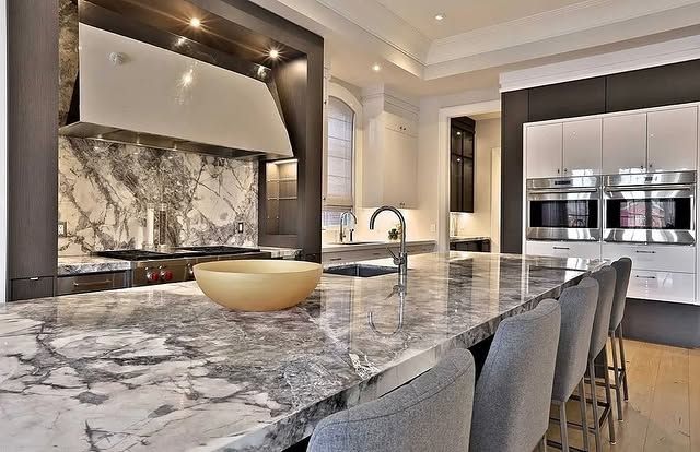A kitchen with a large granite counter top and a bowl on it.