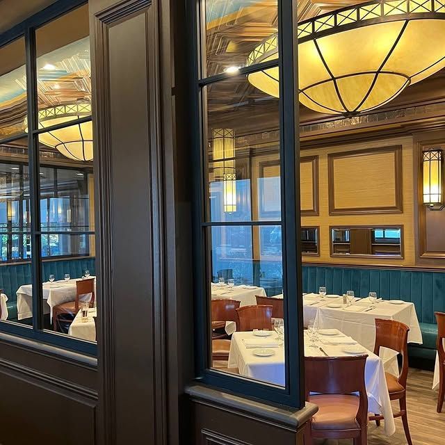 A restaurant with tables and chairs and a large window